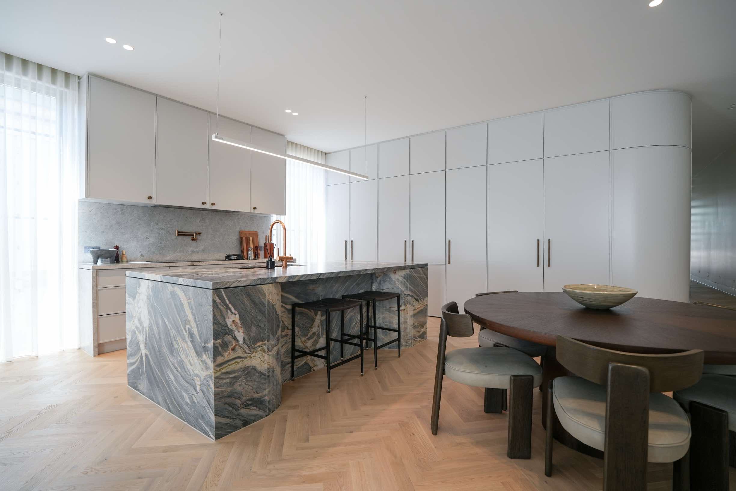 Modern kitchen with marble island and herringbone floors
